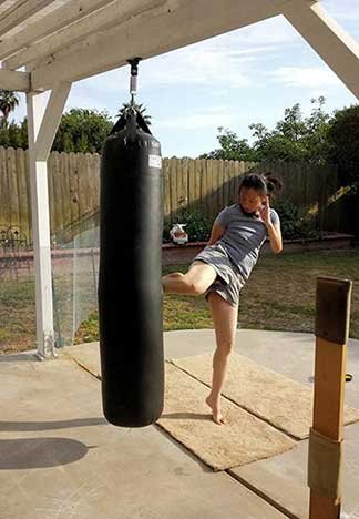 Sandy Performing Low Kick on KO Fightgear Muay Thai Heavy Bag
