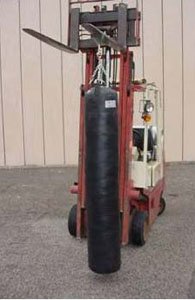 KO Fightgear Muay Thai Heavy Bag hanging from a forklift with swivel chain assembly